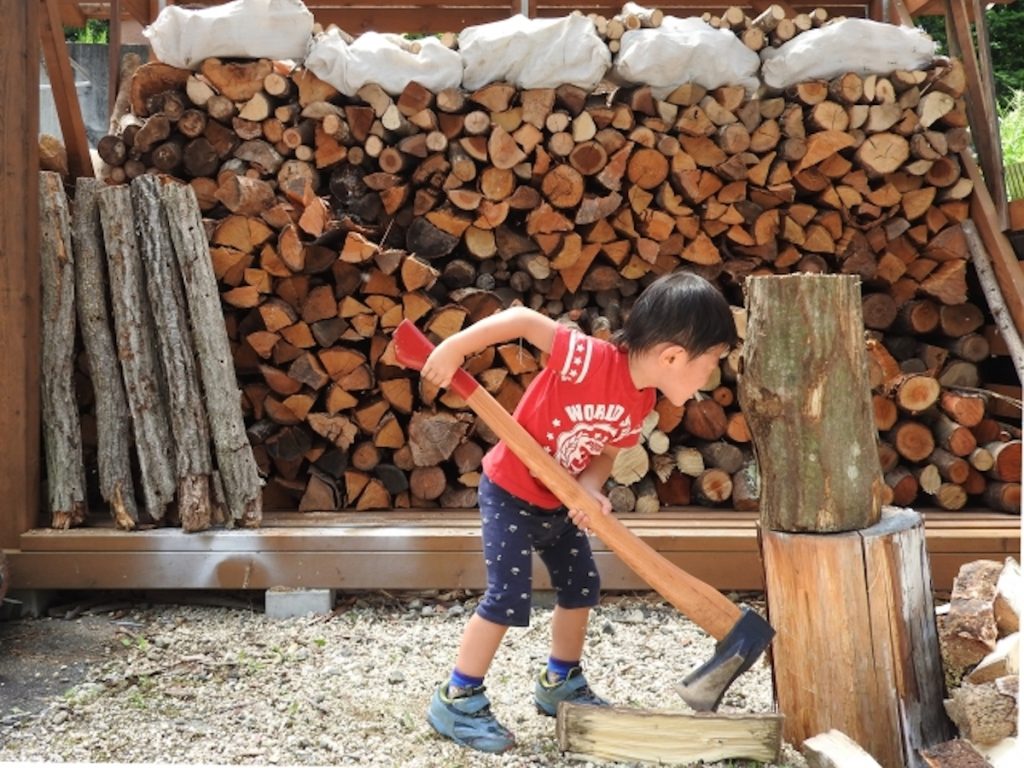 子どもが薪を作ろうとしている写真