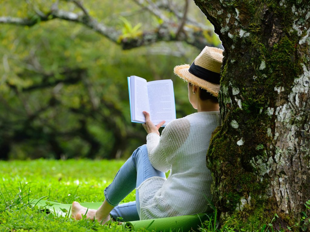 女性が公園で読書をしている写真