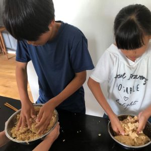 子どもが味噌を作っている写真