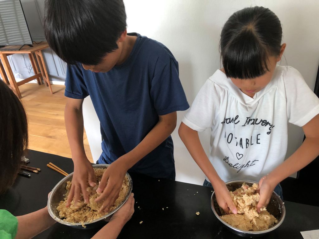 子どもが味噌を作っている写真